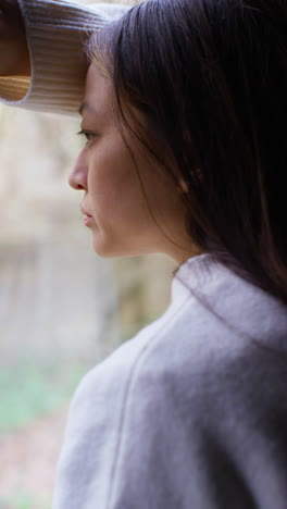 Vertical-Video-Close-Up-Of-Stressed-Or-Anxious-Woman-Suffering-With-Depression-Anxiety-Loneliness-Or-Agoraphobia-Leaning-Against-Window-At-Home-1